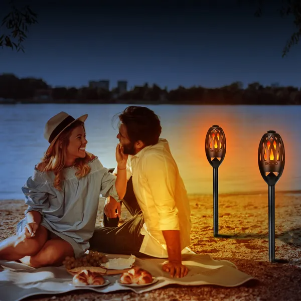 Flame light speakers on a beach at night
